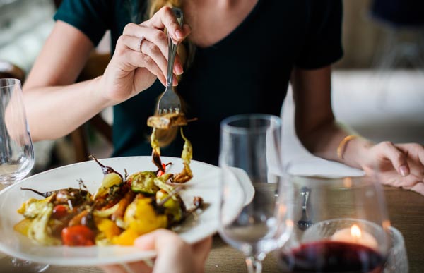 Kobieta jedząca potrawę w restauracji
