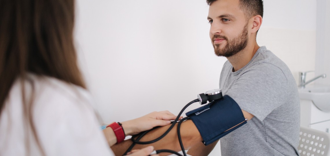 Jak obniżyć ciśnienie krwi - lekarz badający ciśnienie krwi - nowafarmacja.pl